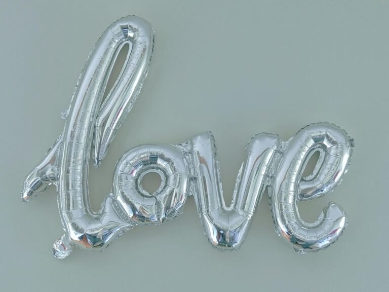 Silver balloon letters spelling 'love' on a light background, perfect for party decor.